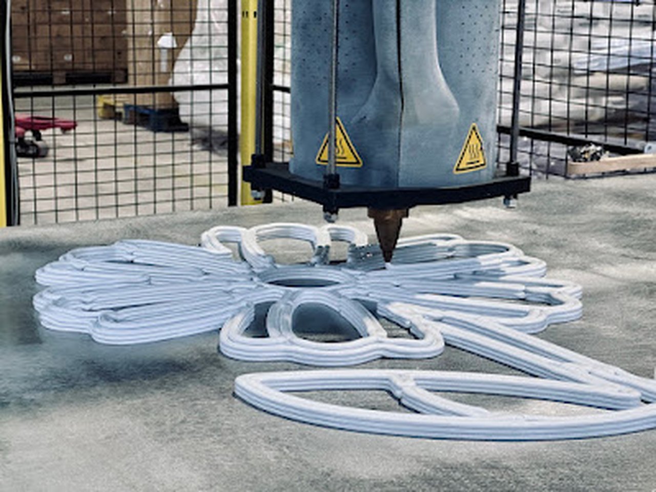 Rozpracovaná 3D tištěná květina na tiskové ploše průmyslové tiskárny.